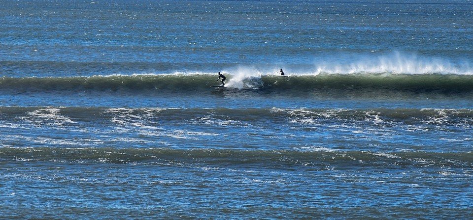 Longboarder on a wave directly in front of the shop